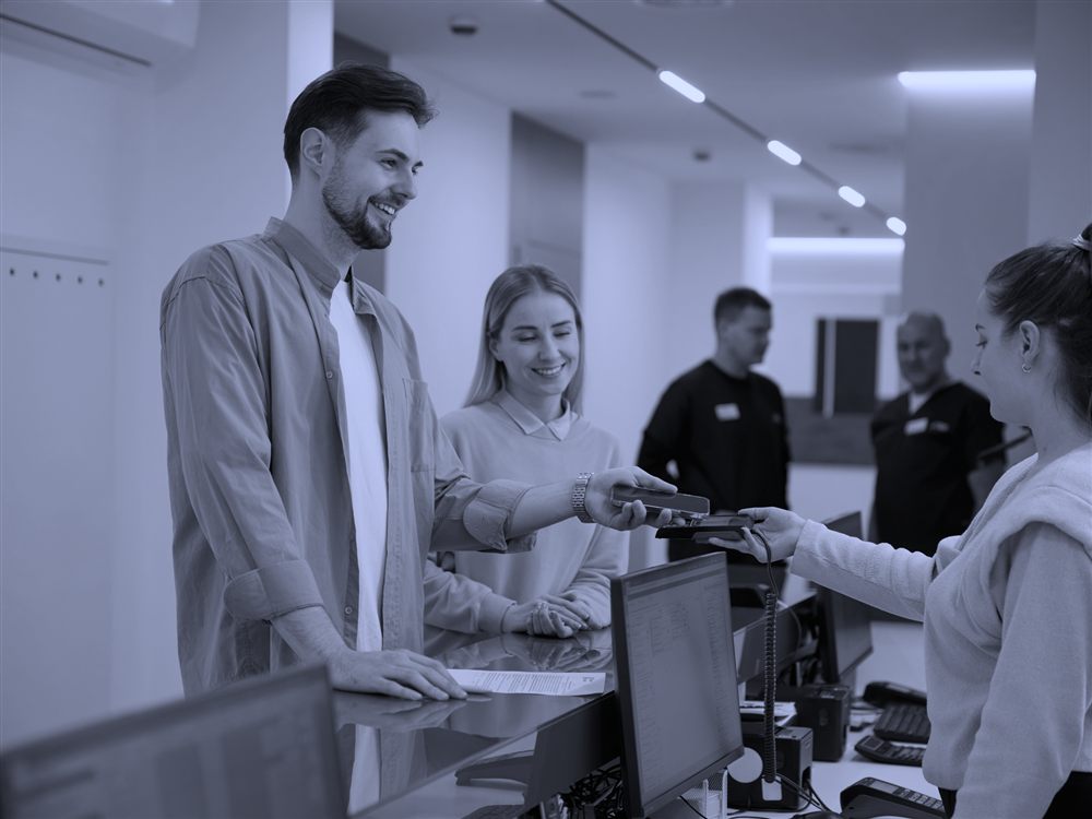 A patient checking out in person while CareCloser handles remote inquiries